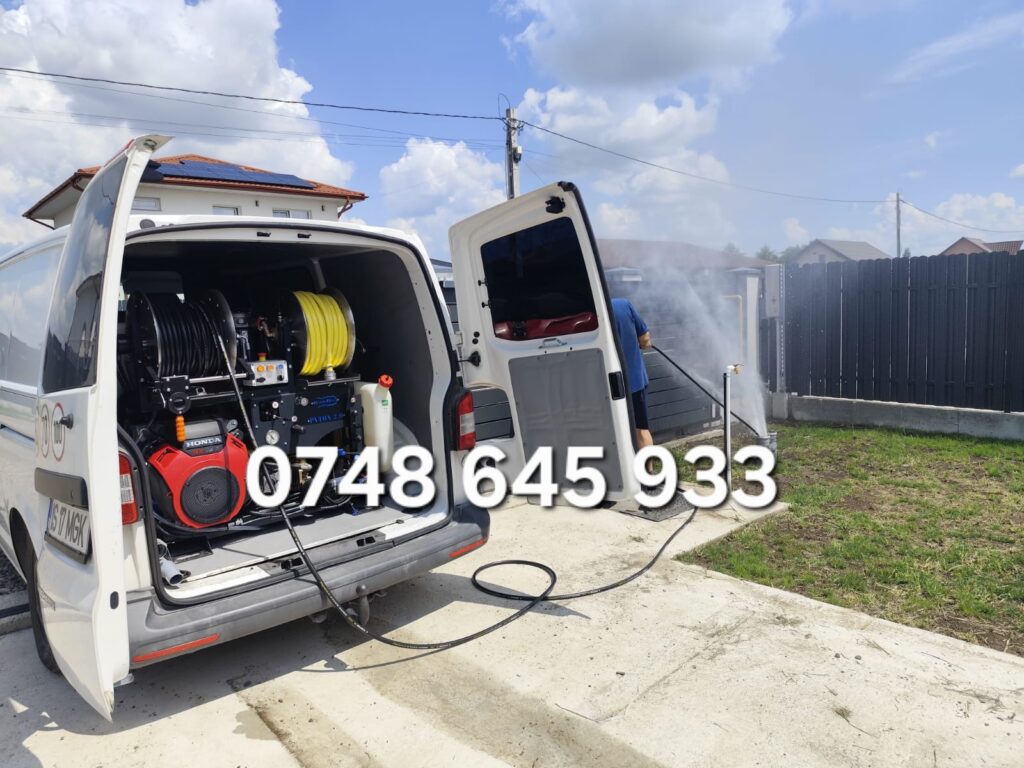 Autospecială dotată cu echipament de desfundare țevi, utilizată la o fosă septică.